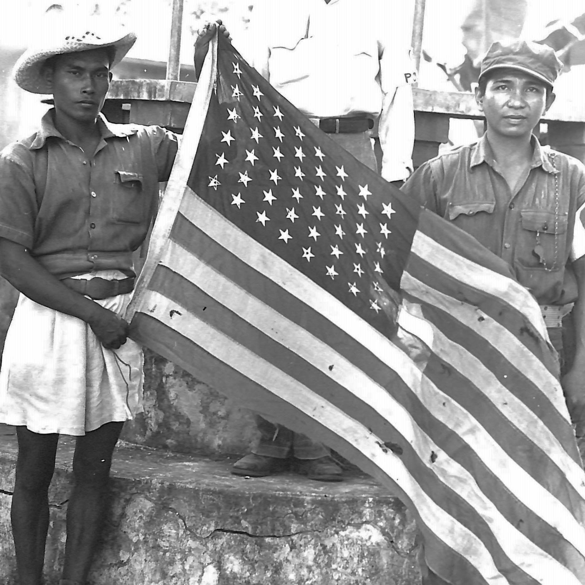 Guerrillas pose with a U.S. flag that was kept hidden throughout the Japanese occupation.
