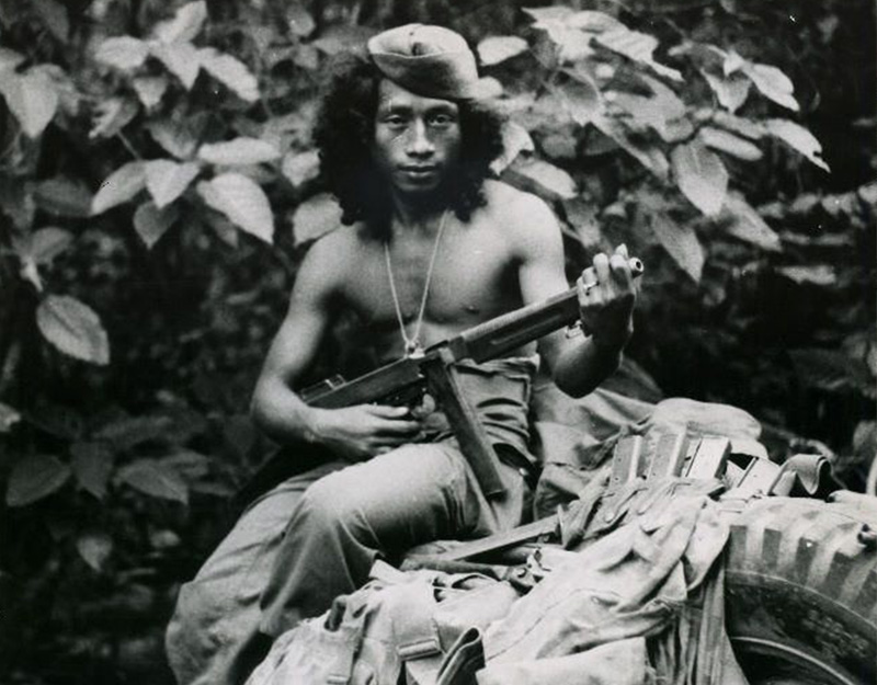 A guerrilla fighter poses with a Thompson machine gun